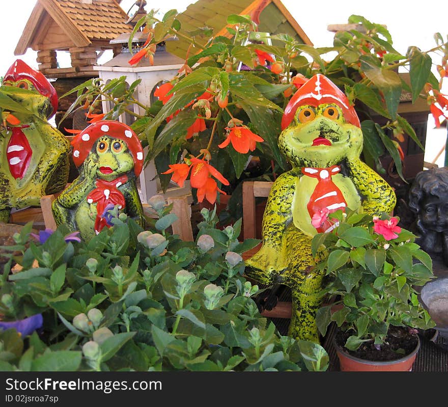 Colorful garden frogs between plants. Colorful garden frogs between plants