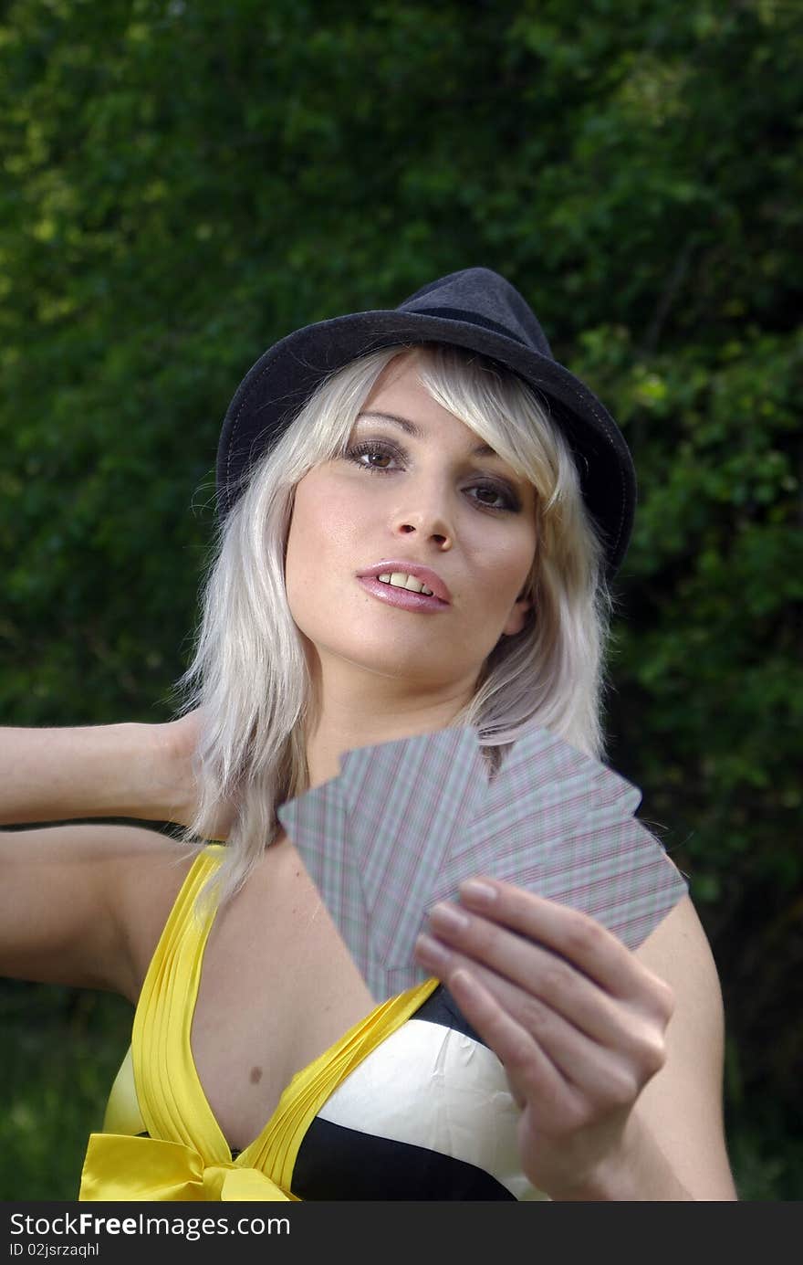 Bleached blonde in a country hat with cards. Bleached blonde in a country hat with cards