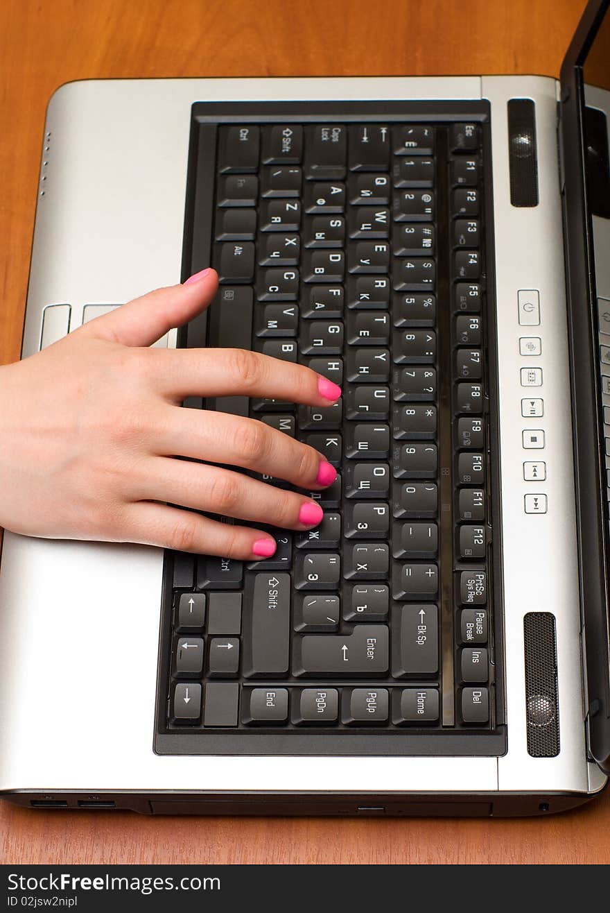 Female hand on the laptop keyboard. Female hand on the laptop keyboard.