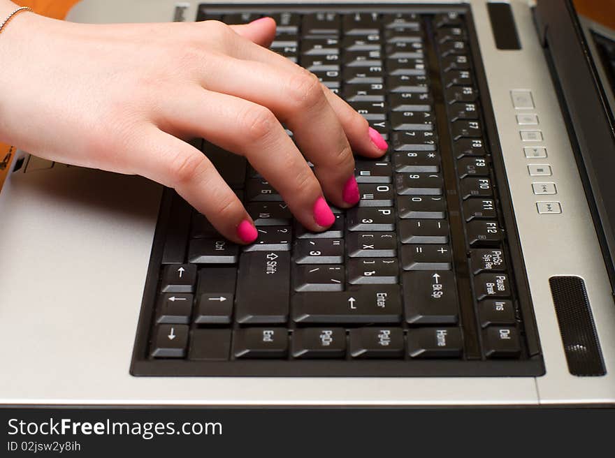 Female hand on the laptop keyboard close up. Female hand on the laptop keyboard close up.