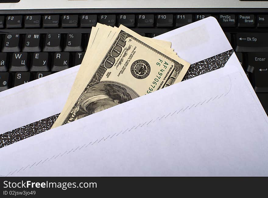 The envelope of dollars in laptop keyboard. The envelope of dollars in laptop keyboard.