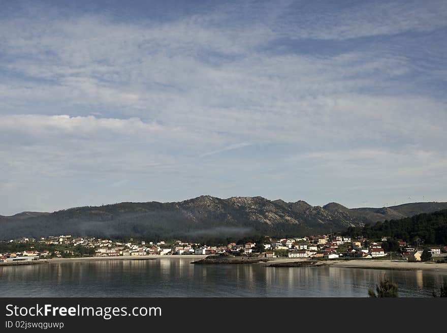 Small fishing village with mountains and sky with clouds. Small fishing village with mountains and sky with clouds