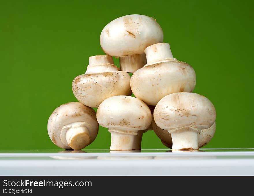 Fresh mushrooms on a white table against the wall