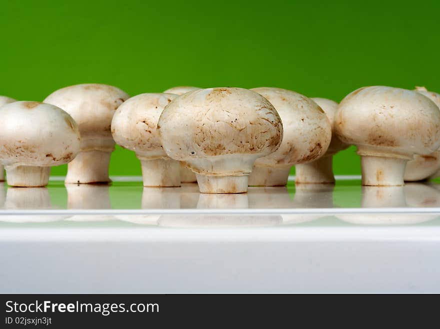 Fresh mushrooms on a white table against the wall