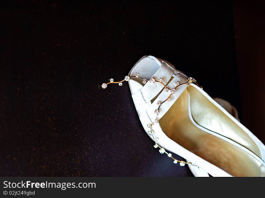 Detail of white wedding expensive shoe with gems. Detail of white wedding expensive shoe with gems.