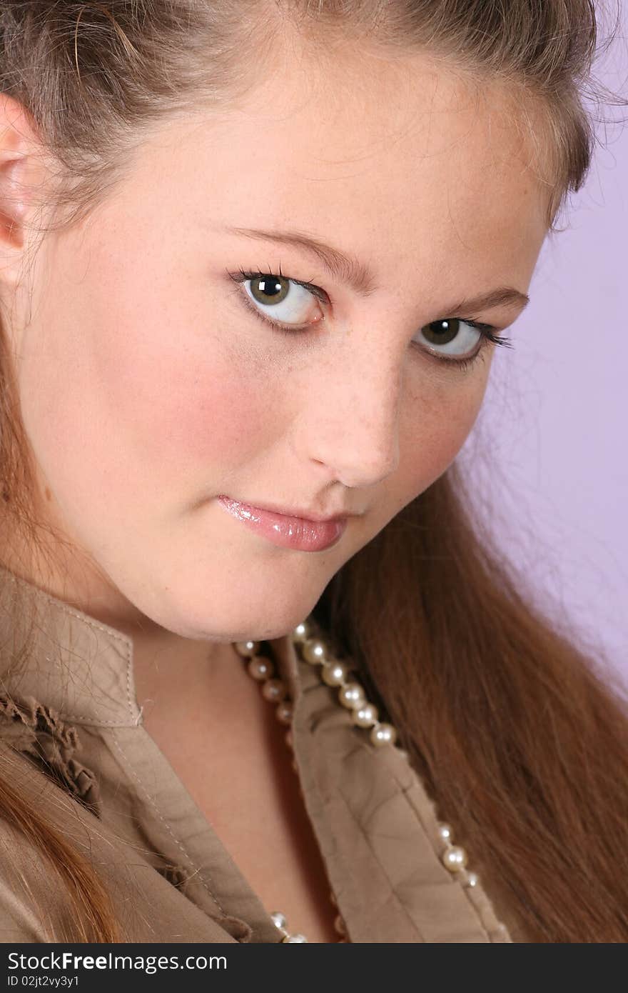 Beautiful teen female wearing pearls against a purple background