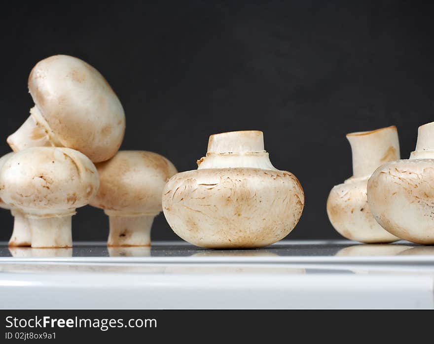 Fresh mushrooms on a white table against the wall