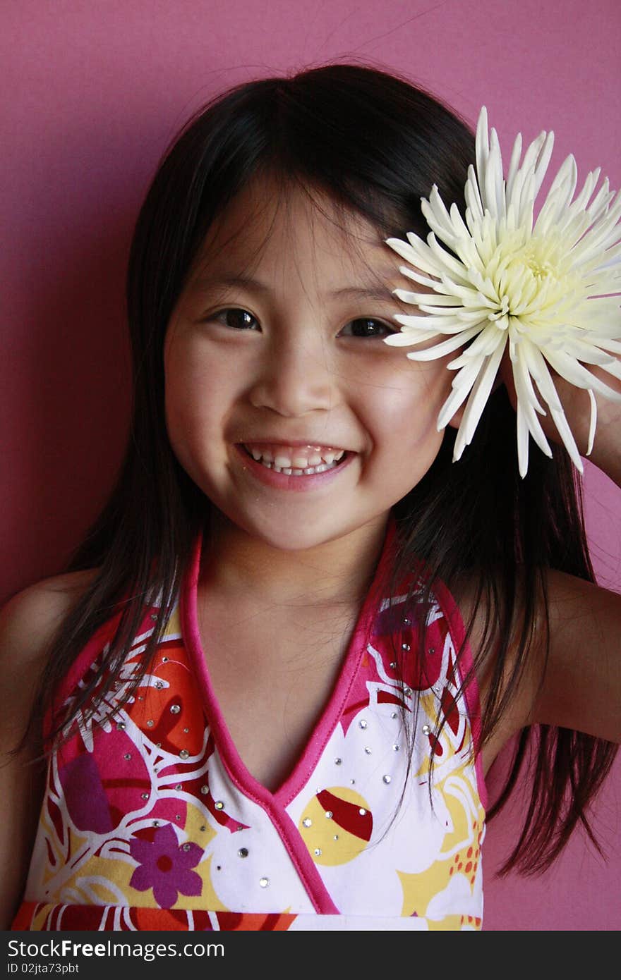 Little asian girl holding flower in her hair. Little asian girl holding flower in her hair