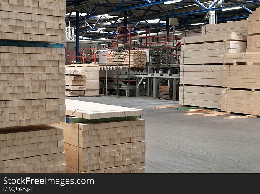 Piled up lumber with the main saw in the background