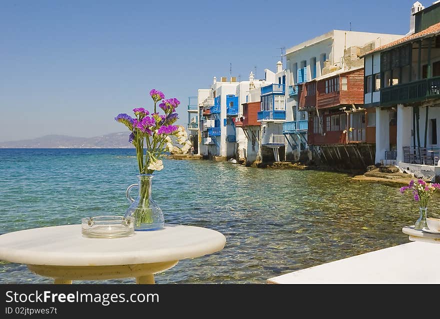 Flowers on the table in a cafe near the sea at Little Venice on Mykonos. Flowers on the table in a cafe near the sea at Little Venice on Mykonos