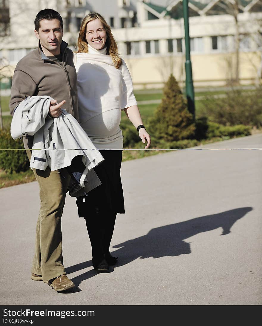 Happy young married family couple outdoor in nature have fun and waiting baby and representing young family growth and pregnancy concept. Happy young married family couple outdoor in nature have fun and waiting baby and representing young family growth and pregnancy concept