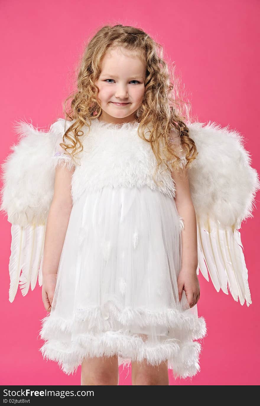 Beautiful little angel girl isolated on pink background