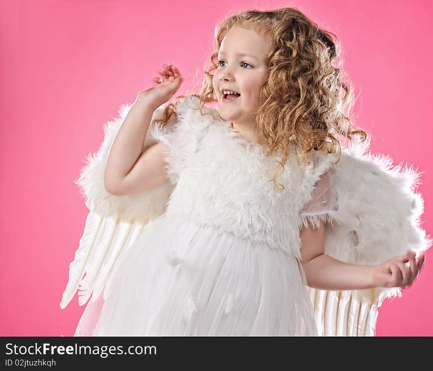 Beautiful little angel girl isolated on pink background