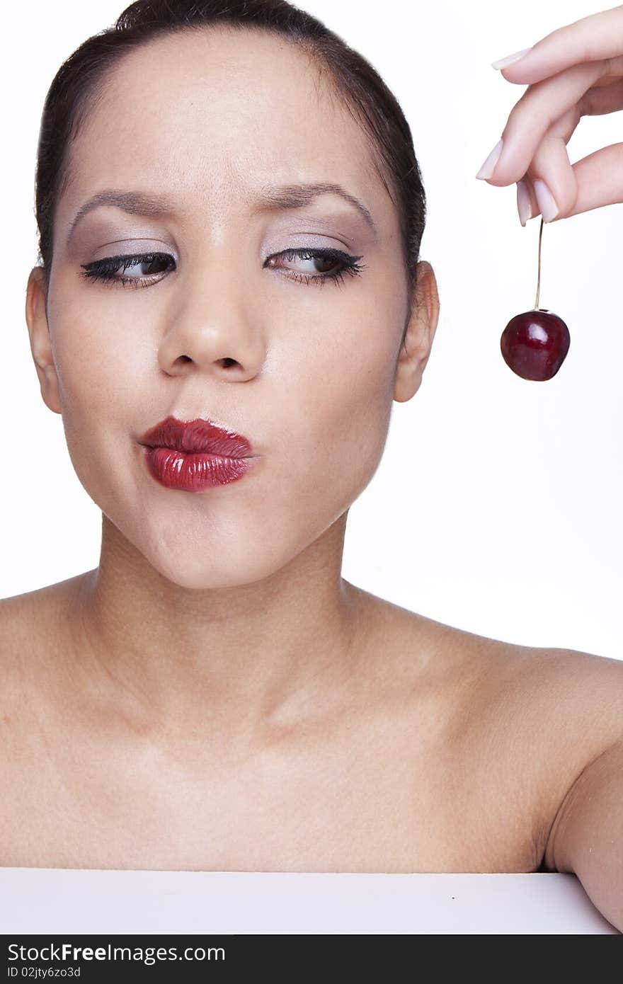 Beauty female face with cherry thinking about to eat .