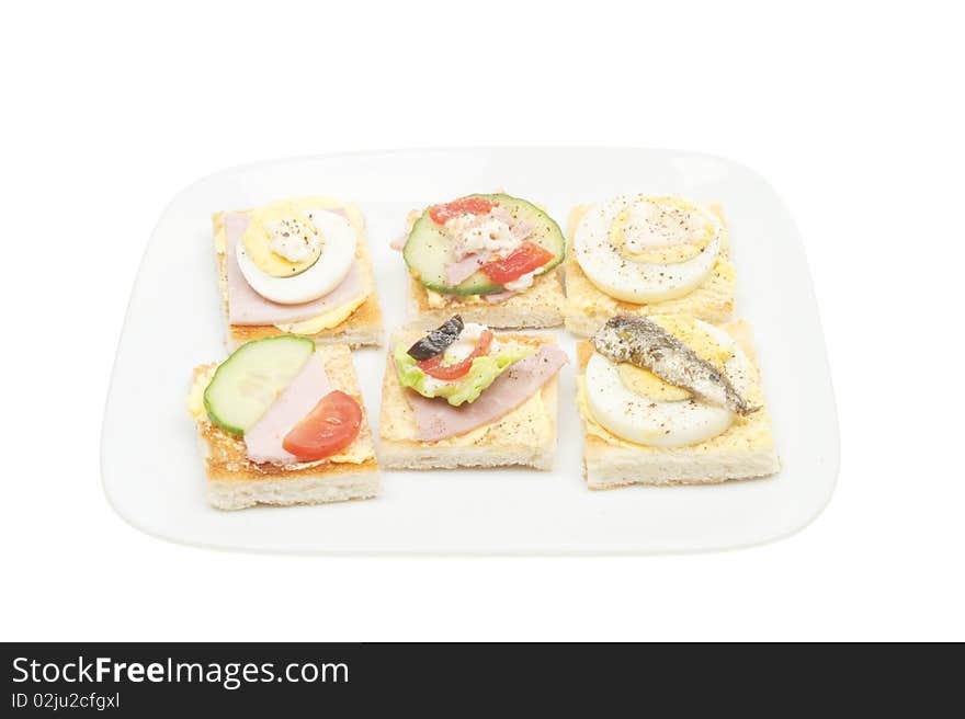 Selection of canapes on a plate isolated on white