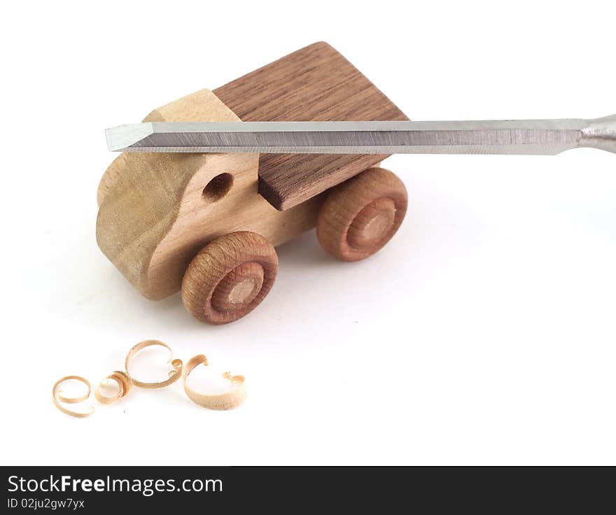 A handmade wooden truck with chisel and shavings. A handmade wooden truck with chisel and shavings