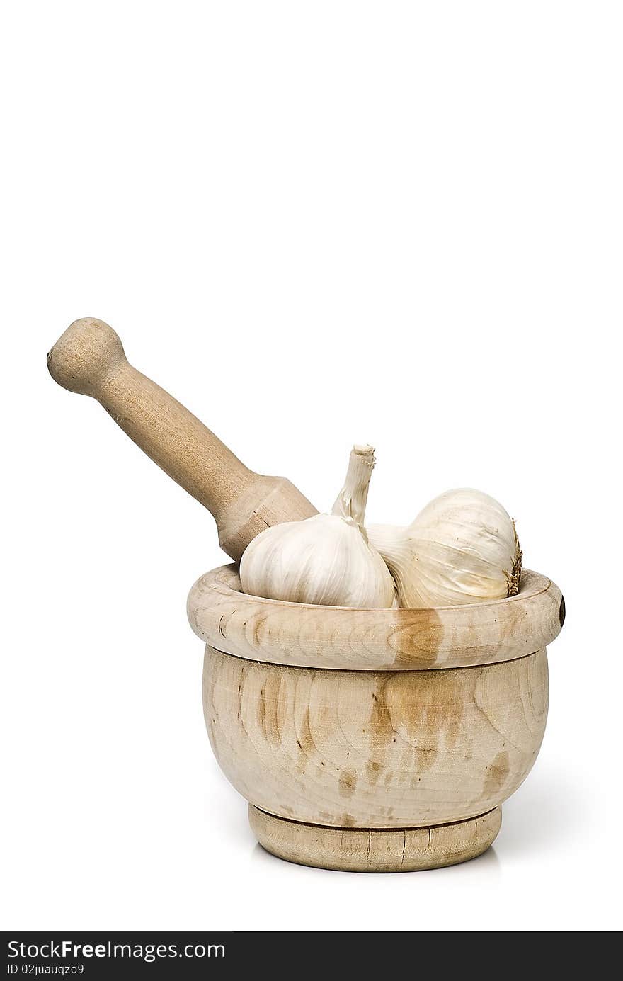 Garlic in a mortar grinder isolated on a white background. Garlic in a mortar grinder isolated on a white background.