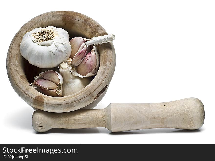 Garlic in a mortar and pestle isolated on a white background. Garlic in a mortar and pestle isolated on a white background.