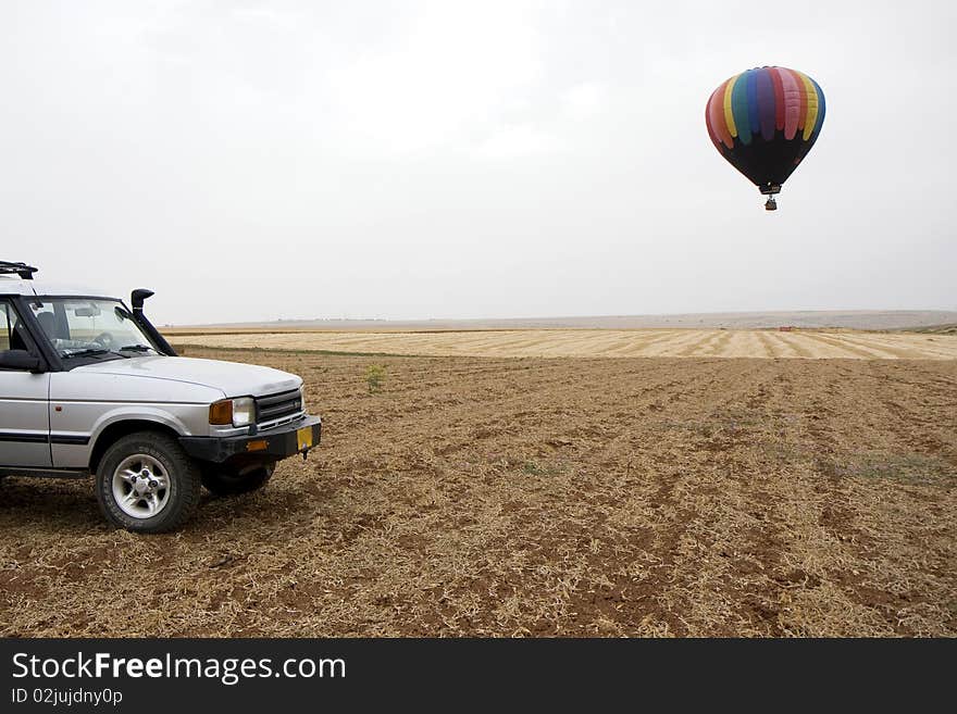 A hot air balloon above fields landscape