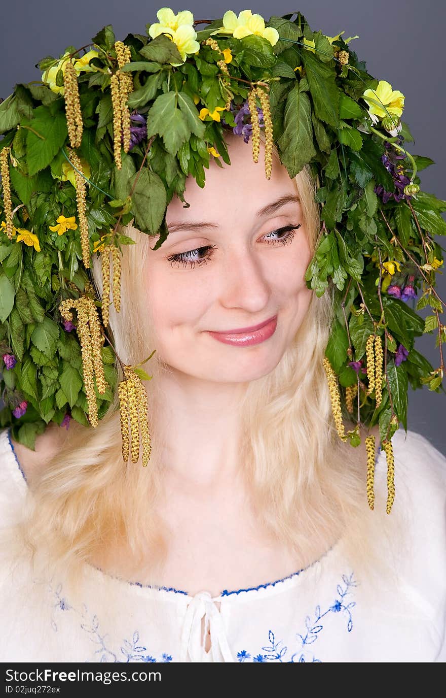 Portrait of a beautiful smiling blonde girl in folk costume and chaplet. Portrait of a beautiful smiling blonde girl in folk costume and chaplet