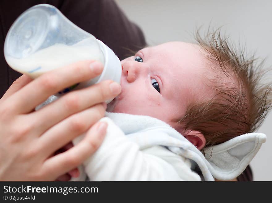 Little baby get milk from a bottle with baby bib. Little baby get milk from a bottle with baby bib