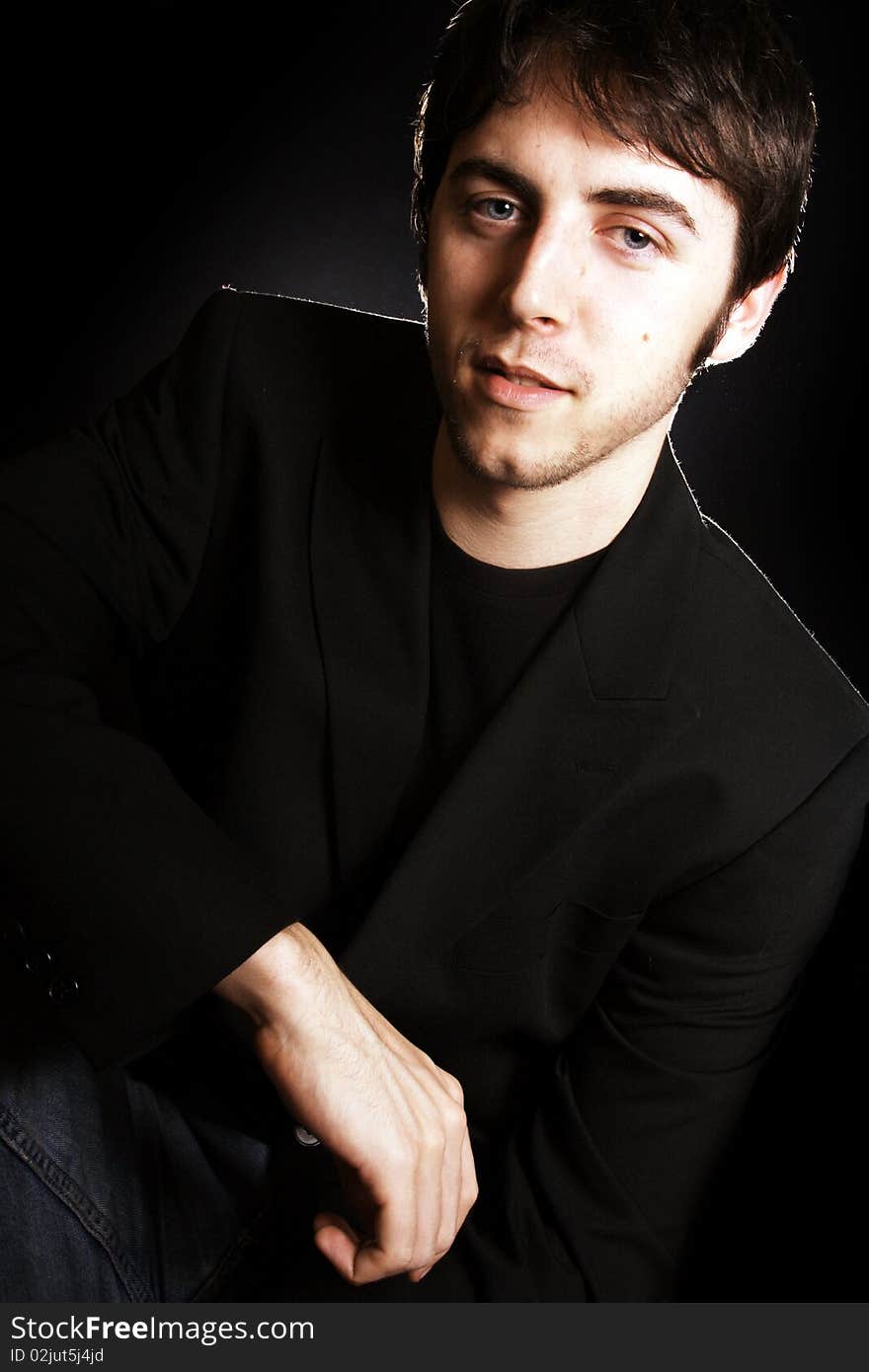 A gorgeous young man backlit and looking at the camera. A gorgeous young man backlit and looking at the camera.