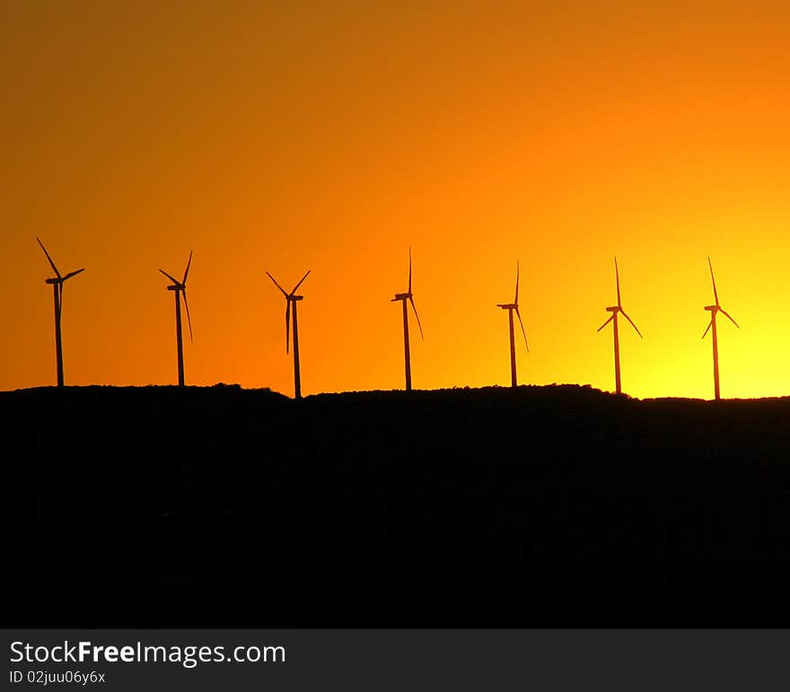 Line of windmills on a hill at dusk. Line of windmills on a hill at dusk