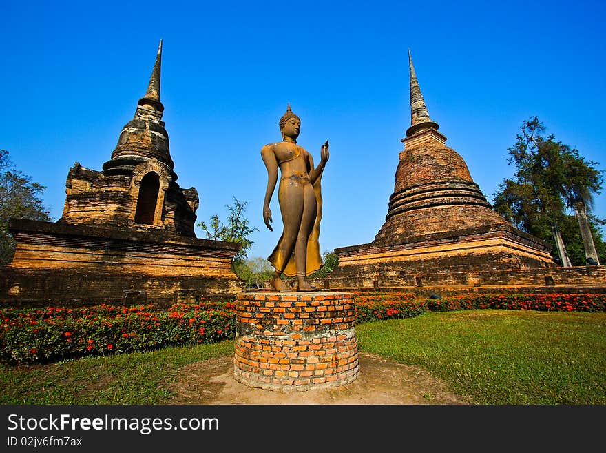 Delicate buddha statue between pagodas in background. Delicate buddha statue between pagodas in background