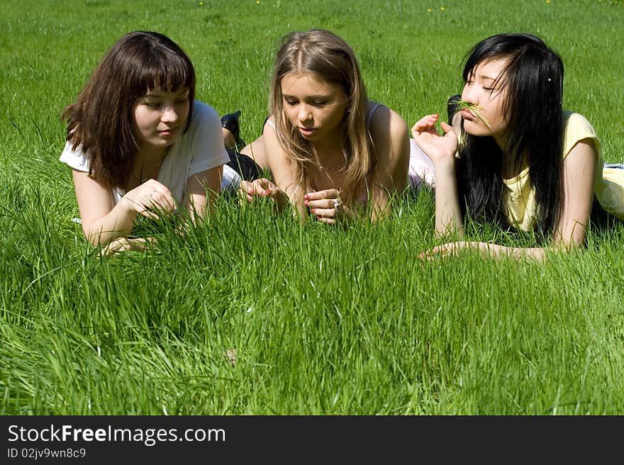 Three girls lying on grass