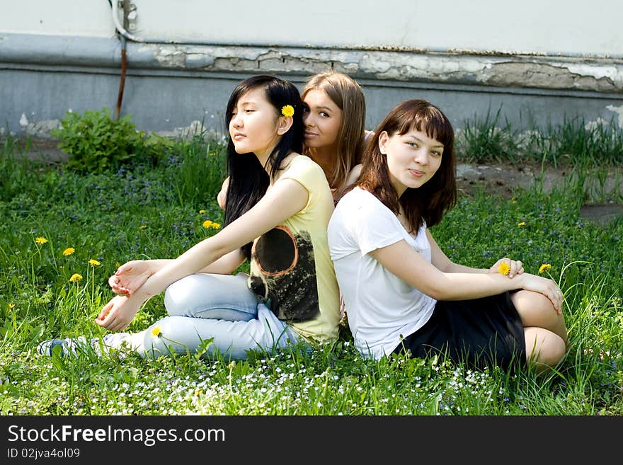 Three girls sitting on grass