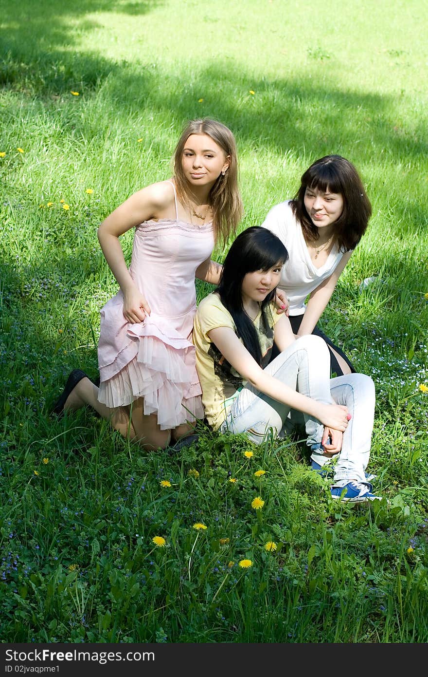 Three girls sitting on grass