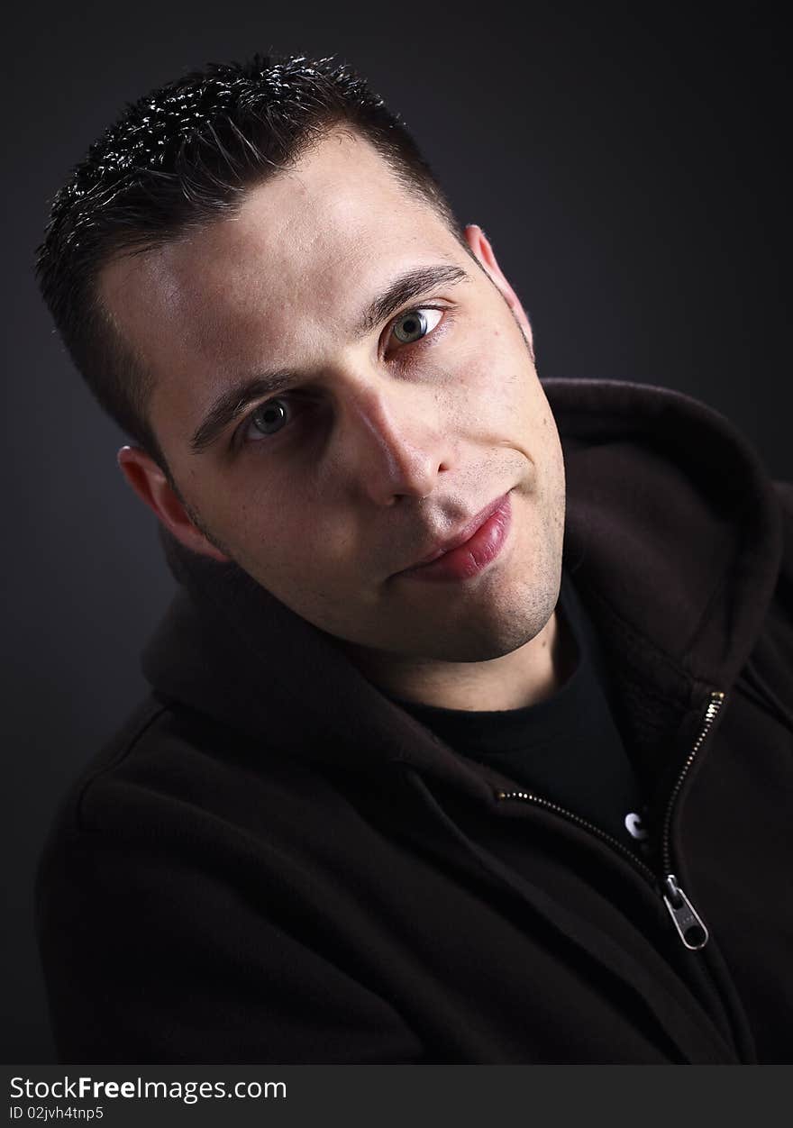 Young man with hoodie portrait on dark background. Young man with hoodie portrait on dark background