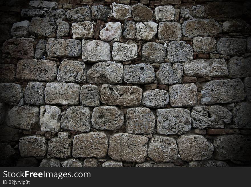 A wall of aged grey stones in line. A wall of aged grey stones in line