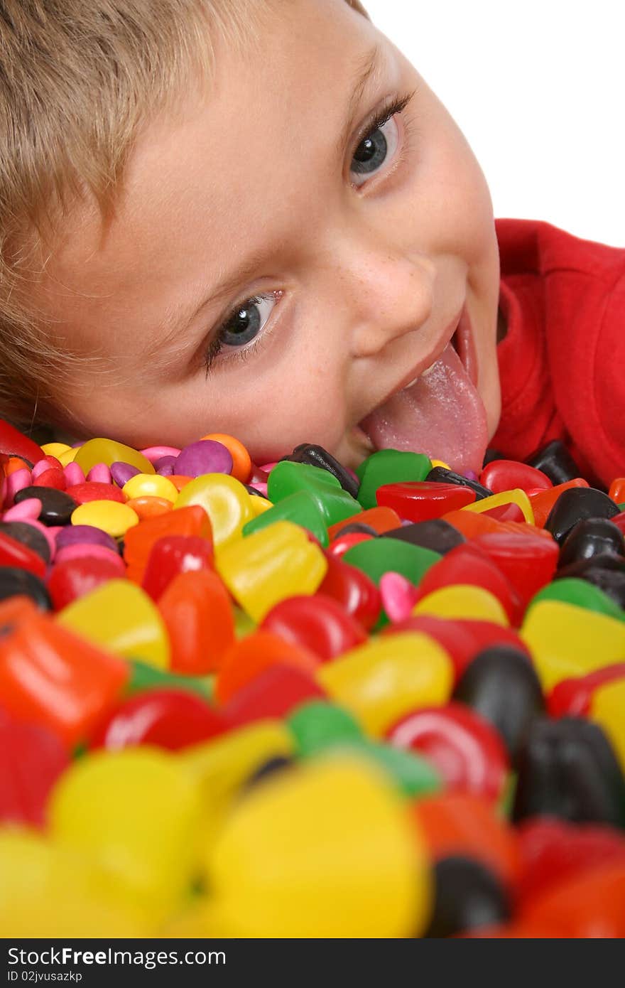 Young boy being with a table full of colorful sweets. Young boy being with a table full of colorful sweets