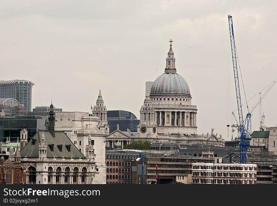 Construction industry and vertical equipments, cloudy sky and Saint Paul Cathdral in background. Construction industry and vertical equipments, cloudy sky and Saint Paul Cathdral in background