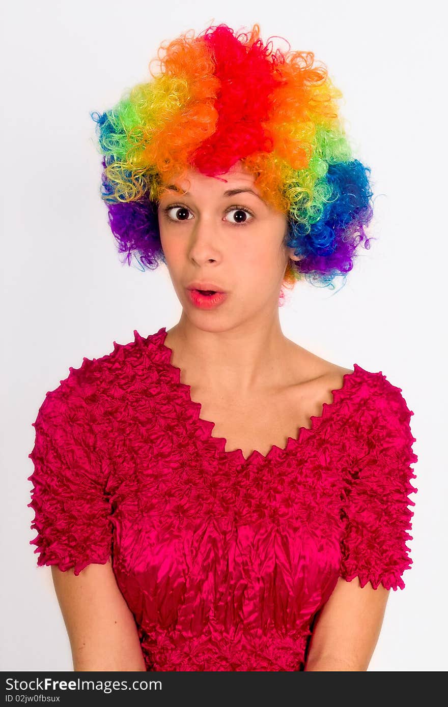 A portrait of a girl in a clown wig, making surprised face. A portrait of a girl in a clown wig, making surprised face