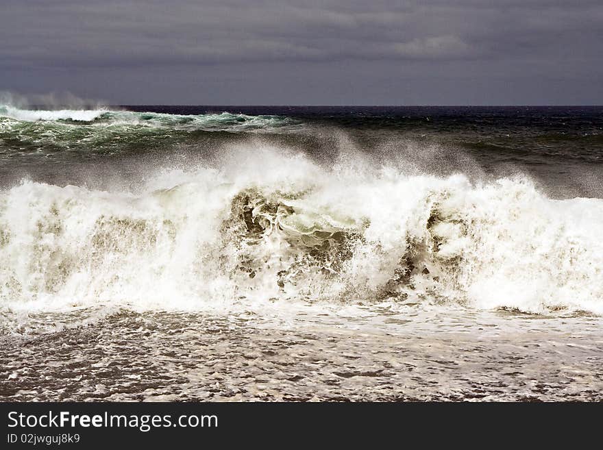 Heavy waves with white wave crest in storm at the beach from Janubio, a volcanic black beach, Lanzarote, Spain