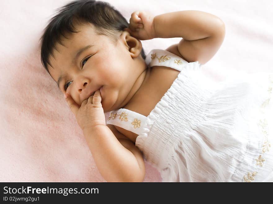 Portrait of a discontent ethnic infant. She is self soothing herself by sucking / nibbling on her fingers. Portrait of a discontent ethnic infant. She is self soothing herself by sucking / nibbling on her fingers.