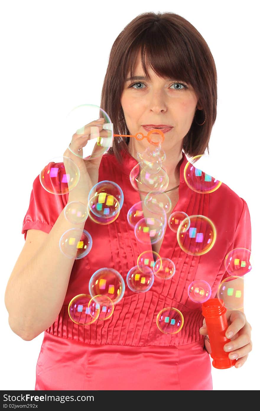 Cheerful woman starts up soap bubbles on a white background