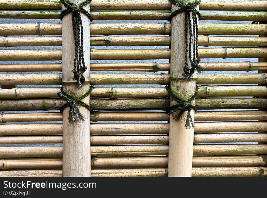 A light colored bamboo fence in a Shinto temple