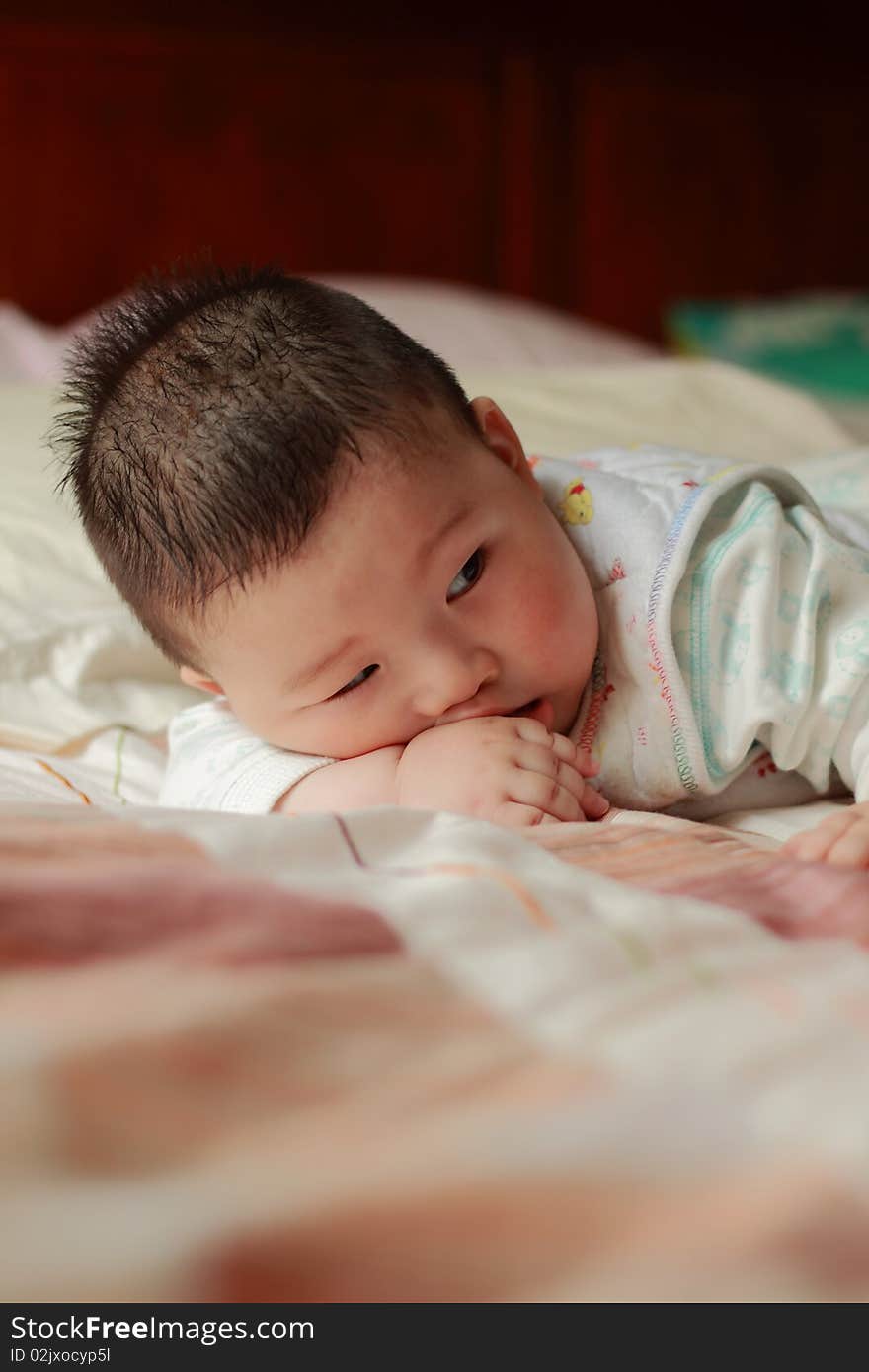 Lovely Chinese baby is playing toy in the bed