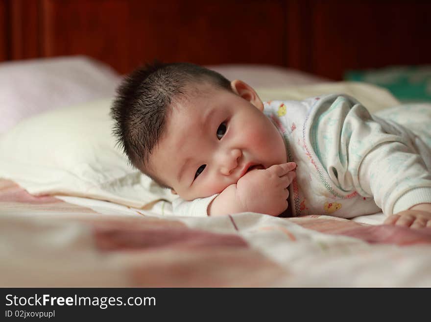 Lovely Chinese baby is playing in the bed