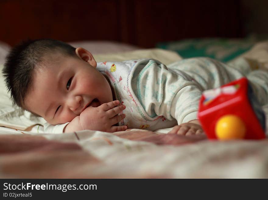 Lovely Chinese baby is playing in the bed