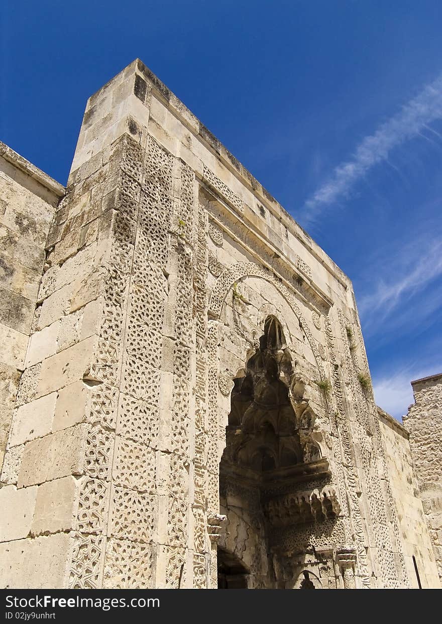 Very old Turkish madrasah gate and blue sky