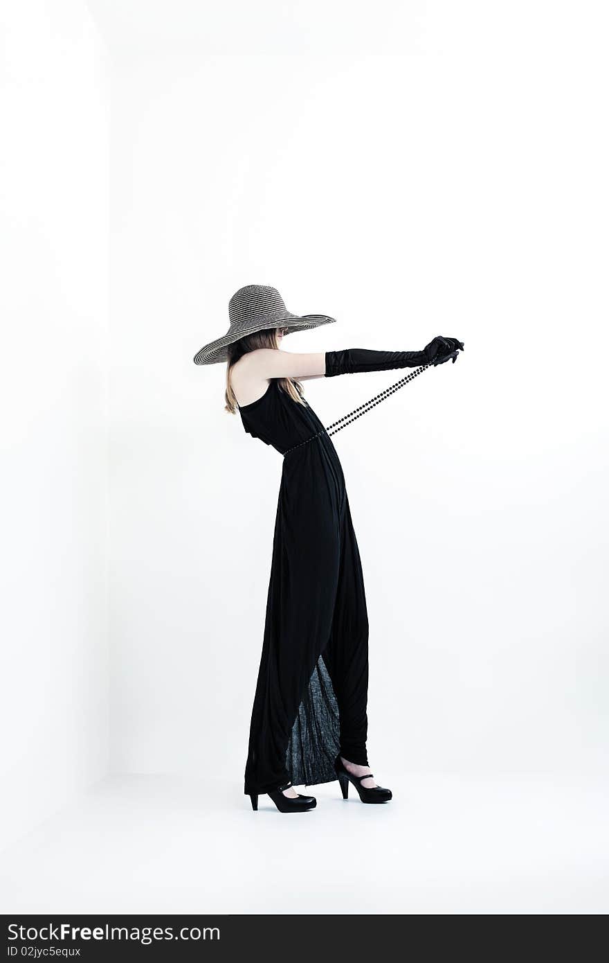 Portrait of a beautiful girl in elegant black dress and a hat. Portrait of a beautiful girl in elegant black dress and a hat.