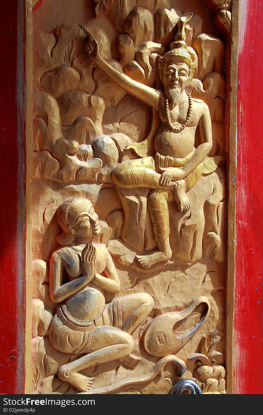 Native Thai style wood carving on door of Buddhist church.