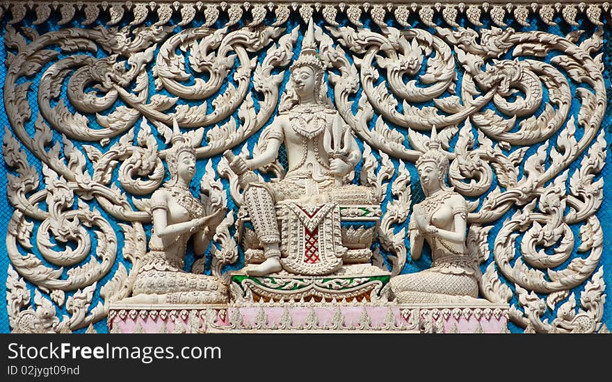 Thai style molding art with blue glass at the wall of temple.