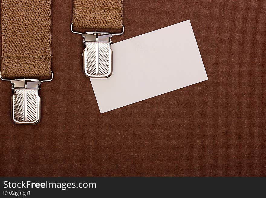 Man's braces about business by a card as a background for design works.