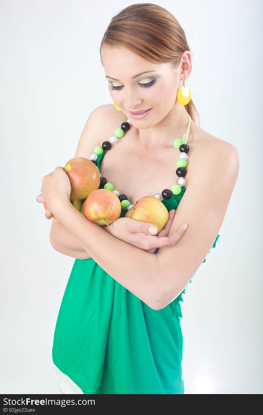 Girl in green sweater holding apples in studio