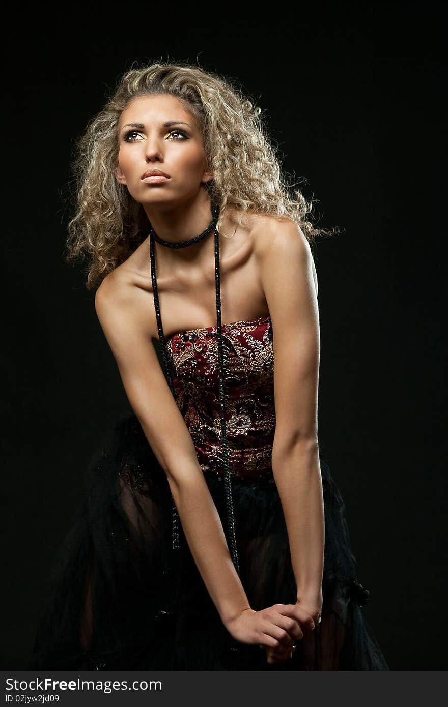 Young beautiful girl with blonde hair poses in the studio